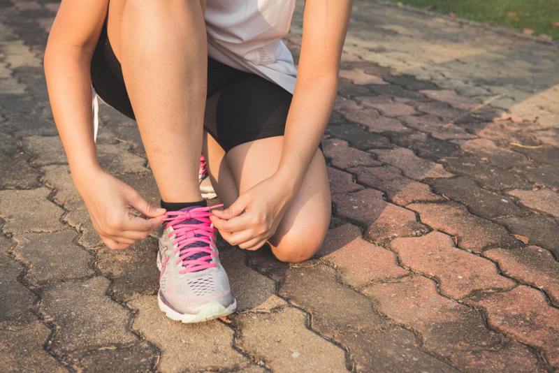 BS Stockfoto vrouw met sportschoen strikken